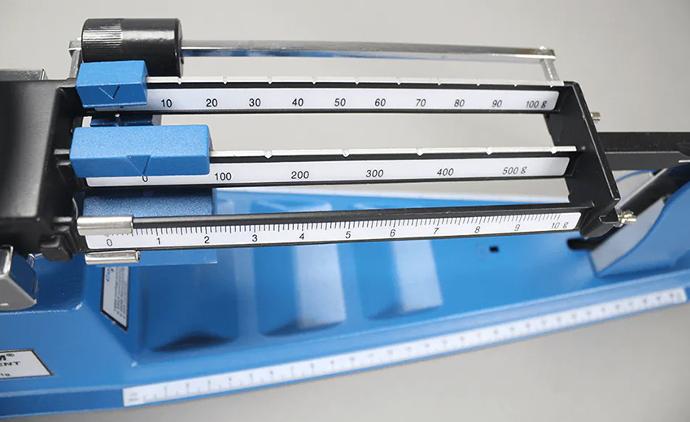 Triple beam balance in a QC lab The weighing arms of a triple beam balance in the quality control lab at an industrial manufacturer.